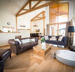 A living room with two sofas a wooden coffee table and a large round cushion at Aurae in Cawdor near Inverness