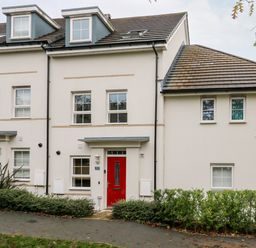 A row of white houses with red front doors and multiple windows at 20 Bishops Way in Falmouth