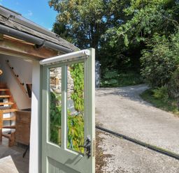 A doorway showing a staircase and shelving at Little Coombe Trehunist near Liskeard