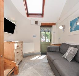 A living room with a sofa and television at Little Coombe Trehunist near Liskeard