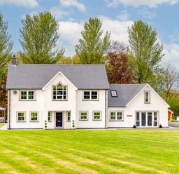A large house with multiple windows and a gray roof surrounded by trees and lawns at Parc Y Deri in Rhos-y-garth near Aberystwyth