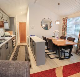 A dining room with a table and chairs at Merewood in Troutbeck Bridge