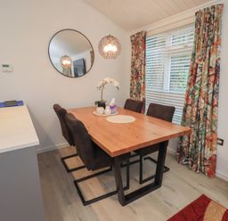 A dining room with a table and chairs at Merewood in Troutbeck Bridge