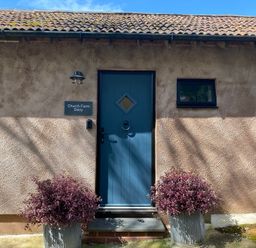 A blue door with a sign at Church Farm Dairy Cadbury near Thorverton