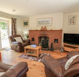 A living room with a fireplace and sofa at Felin Gogoyan Tregaron