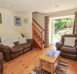 A living room with a sofa and coffee table at Felin Gogoyan in Tregaron