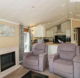 A living room with recliner chairs and a kitchen area at Daisy in Eardisland