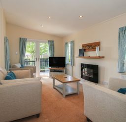 A living room with a sofa and television at Daffodil in Eardisland
