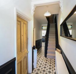 A hallway with a staircase and a door at Sunrise House Pakefield near Lowestoft
