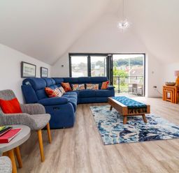 A living room with a sofa and television at Pebble Ridge View Westward Ho!