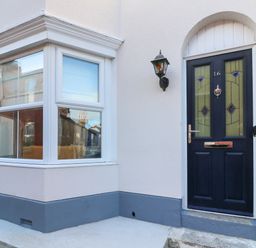 Front door with house number 16 and adjacent bay window of a house at Bay Cottage in Weymouth