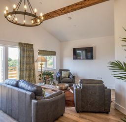 A living room with a sofa and television at Heritage Retreat in Monknash