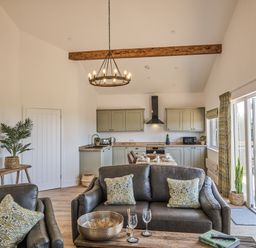 A living room with a kitchen area at Heritage Retreat Monknash