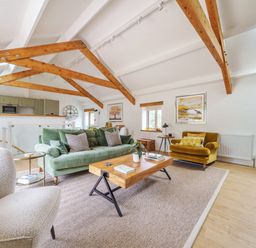 A living room with sofas wooden coffee table and exposed ceiling beams at The Granary in Davidstow near Camelford