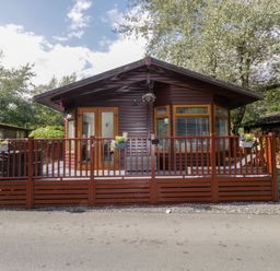 A house with a deck and planters at Ruskin Lodge, Langdale 16, White Cross Bay near Windermere