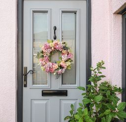 A front door with a floral wreath and a plant beside it at Moon's Cottage in Fowey