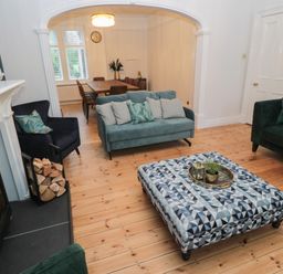 A living room with sofas armchairs coffee table and dining table with chairs at St Aidans in Alnwick