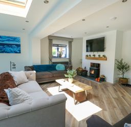 A living room with a sofa and coffee table at Iscoed in Rhosneigr