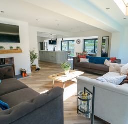 A living room with a television and fireplace at Iscoed Rhosneigr