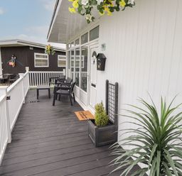 A porch with chairs a table and plants at 39 Cherry Park in Chapel St Leonards