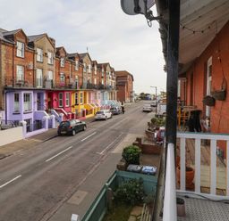 A street with parked cars and multicolored houses viewed from a balcony at 11a Manning Road in Felixstowe Suffolk