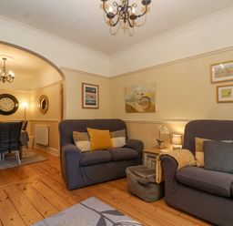 A living room with two sofas and cushions and a dining area with a table and chairs at Green Gate Cottage in Reydon near Southwold