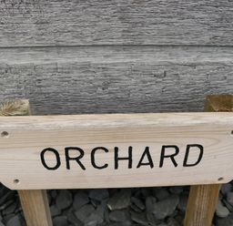 A wooden sign with the word orchard in black letters outdoors at Orchard in Dalton-In-Furness