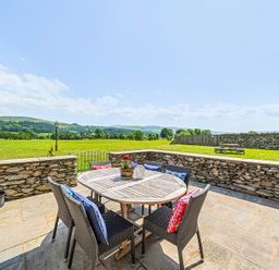 An outdoor dining area with a table and chairs at Hay Store in Corwen
