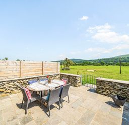 An outdoor patio with a table and chairs at Hay Store in Corwen