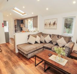 A living room with a sofa and coffee table at Willows Lodge, White Cross Bay, near Windermere