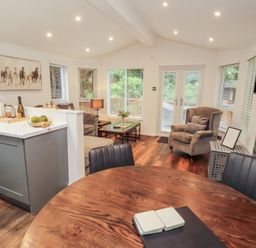 A living room with a table and chairs at Willows Lodge, White Cross Bay, near Windermere