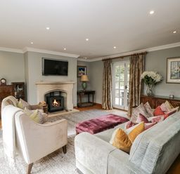 A living room with a fireplace and sofa at The Old Hall in Tetbury