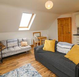 A living room with two sofas and a small dining table under a skylight window at Old Field Hideaway Slade near Fethard-On-Sea County Wexford