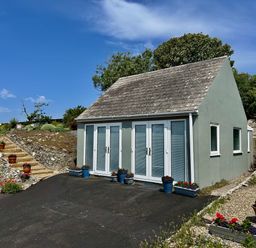 A house with doors and windows surrounded by garden at Tower Cottage Near Pembroke