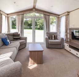 A living room with a sofa armchair coffee table and fireplace at 7 The Oaks in Long Preston near Hellifield