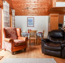 A living room with two armchairs and a dining table with chairs at Trout River Retreat Clifford Bridge near Moretonhampstead