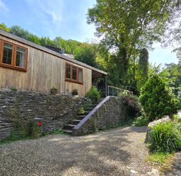 A wooden house with a gravel driveway at Ty Barddu Cwmorgan near Newcastle Emlyn
