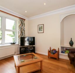 A living room with a television on a stand beside a window and a coffee table in the center at Silver How in Ambleside