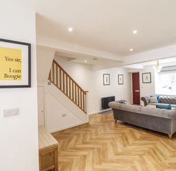 A living room with a staircase and a sofa at Neptune Cottage in Conwy