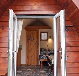 A pod with a bed and table at Pod 2 in Beauly
