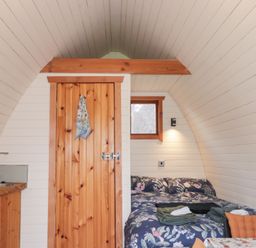 A bedroom with a bed and a door at Pod 2 in Beauly