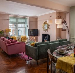 A living room with a sofa and dining area at Astondene, East Cliff Southwold