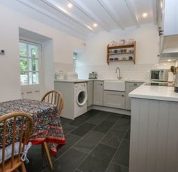 A kitchen with a table and appliances at Chandos in Dolwyddelan