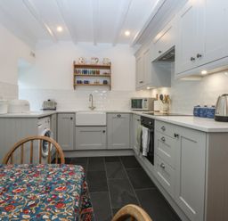 A kitchen with appliances and a dining table at Chandos in Dolwyddelan
