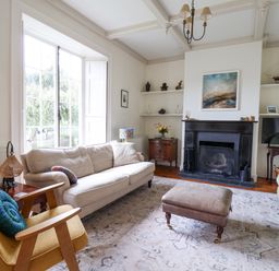A living room with sofas a fireplace a television and a window at Charmouth Lodge in Charmouth