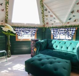 A sitting room with a green sofa and vase at Applejacks Orchard Holywell