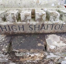 A carved stone with the words High Shaftoe on a stone wall at High Shaftoe in Ponteland