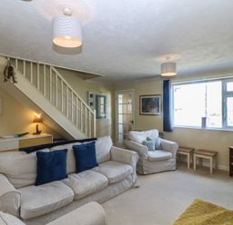 A living room with a sofa and TV at Wingelock in Rhosneigr
