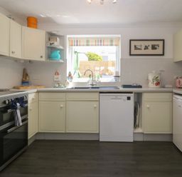 A kitchen with an oven, sink, and dishwasher at Wingelock in Rhosneigr
