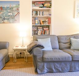 A living room with two gray sofas and a side table with a lamp between them at The Old Lace Shop in Beer